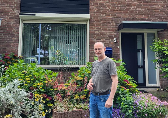 Bewoner staat voor zijn huis die hij verduurzaamd heeft