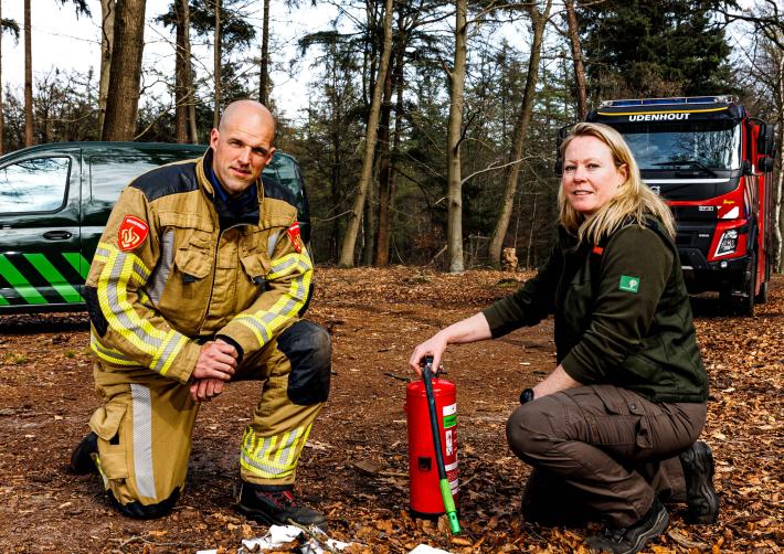 brandweerman en boswachter bij smeulend afval
